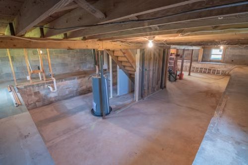 An unfinished basement with a concrete floor